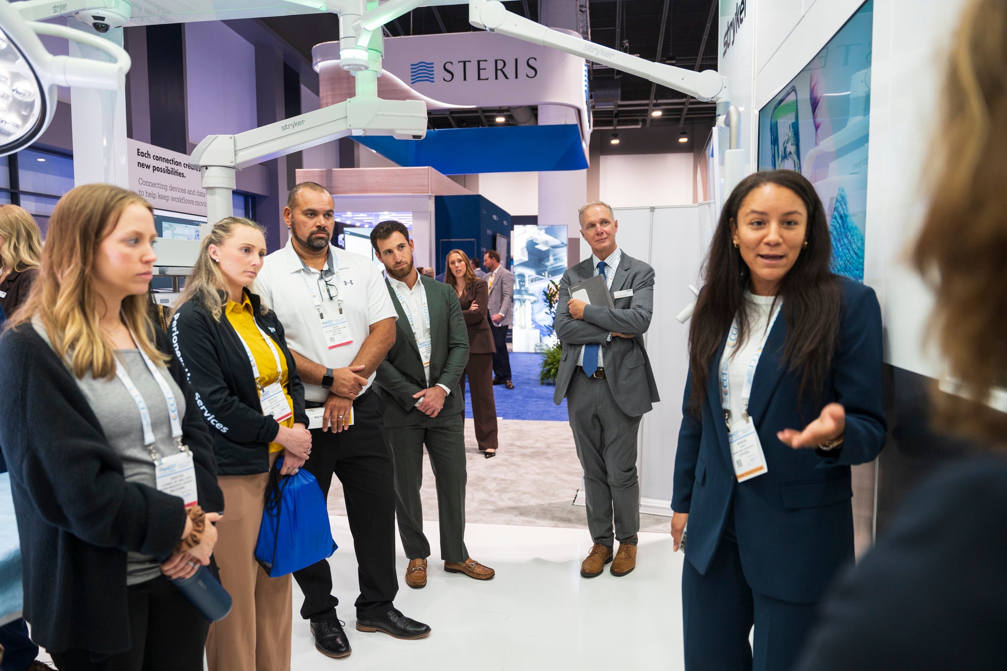 An exhibitor presenting to a group of attendees at a booth