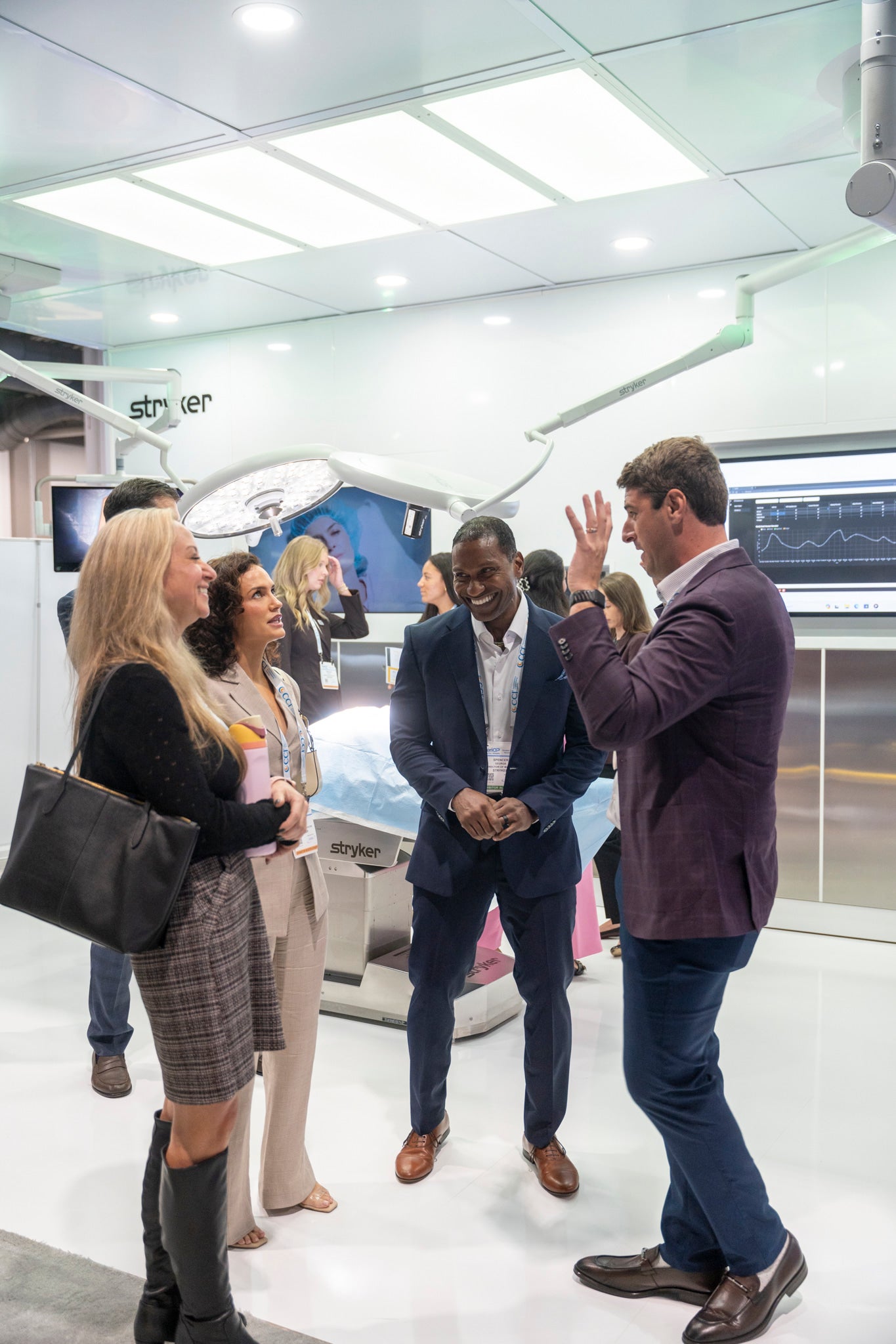 Attendees and an exhibitor in conversation inside a booth